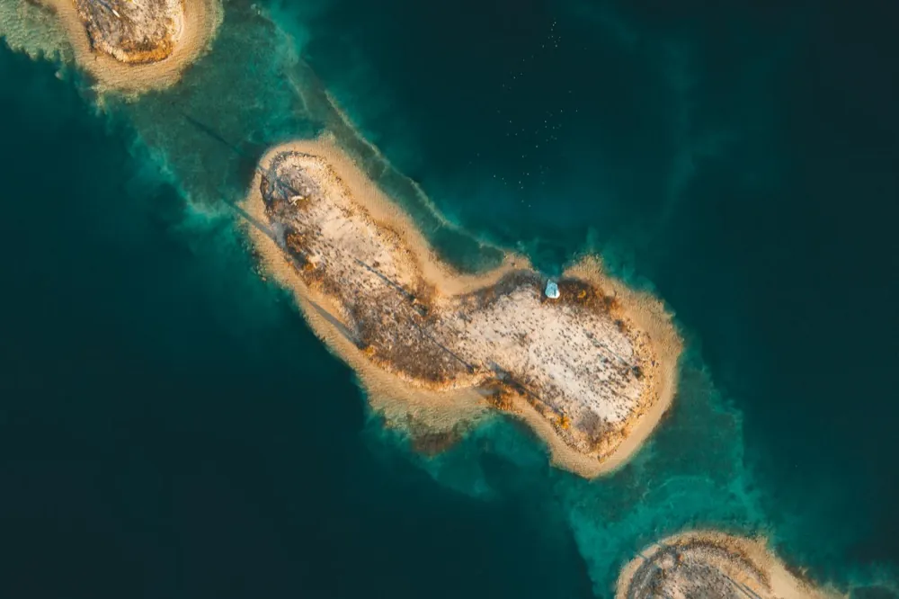 Charter boat anchored off a sandy South Florida island with clear shallow water and mangroves in the background