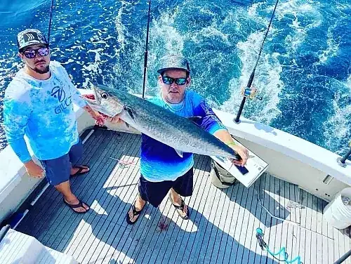 Small group of anglers fishing from the deck of a private sportfishing charter boat off Pompano Beach