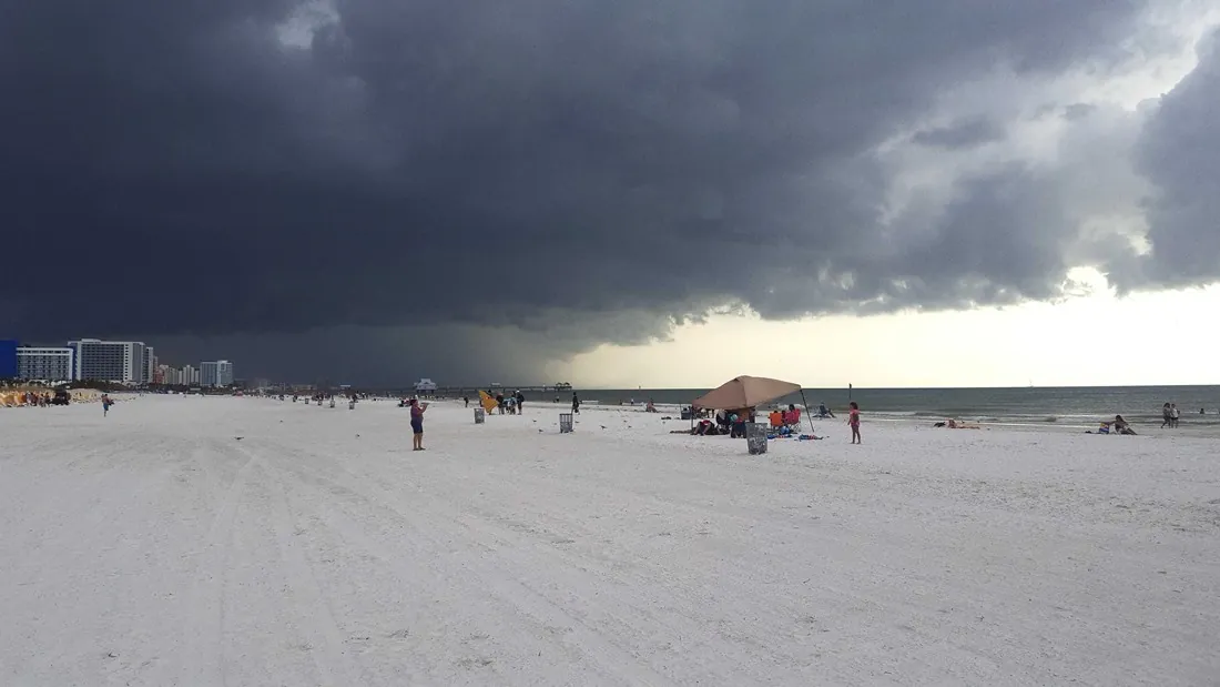 Dark storm clouds building over the Atlantic as a sportfishing boat heads back toward Hillsboro Inlet in Pompano Beach