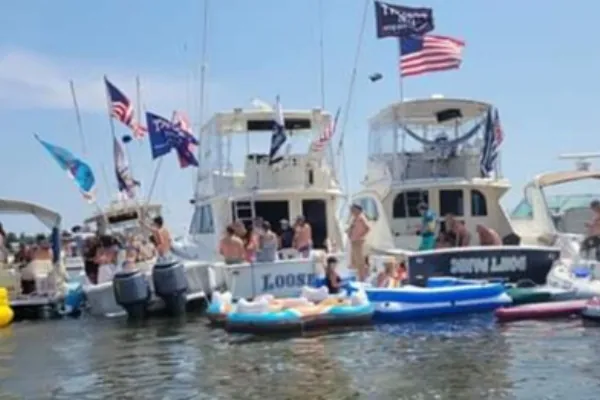 Friends swimming and floating beside an anchored charter boat at a sandbar near Hillsboro Inlet in Pompano Beach