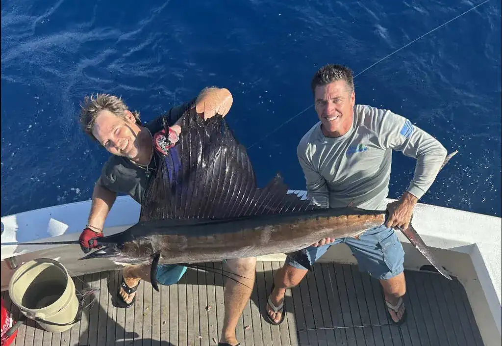 Angler fighting a fish on a bent rod aboard an offshore fishing charter in the Gulf Stream off Pompano Beach