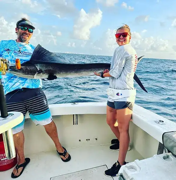Mate rigging bait on the deck of sportfishing charter Don't Panic before leaving Hillsboro Inlet in Pompano Beach