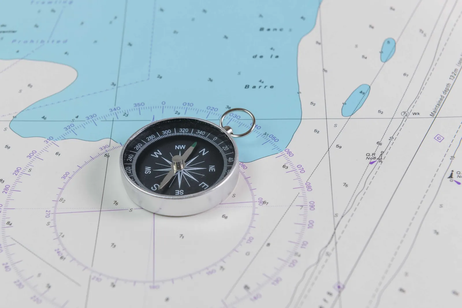Captain reviewing a nautical chart and GPS chartplotter at the helm of a fishing charter boat off Pompano Beach