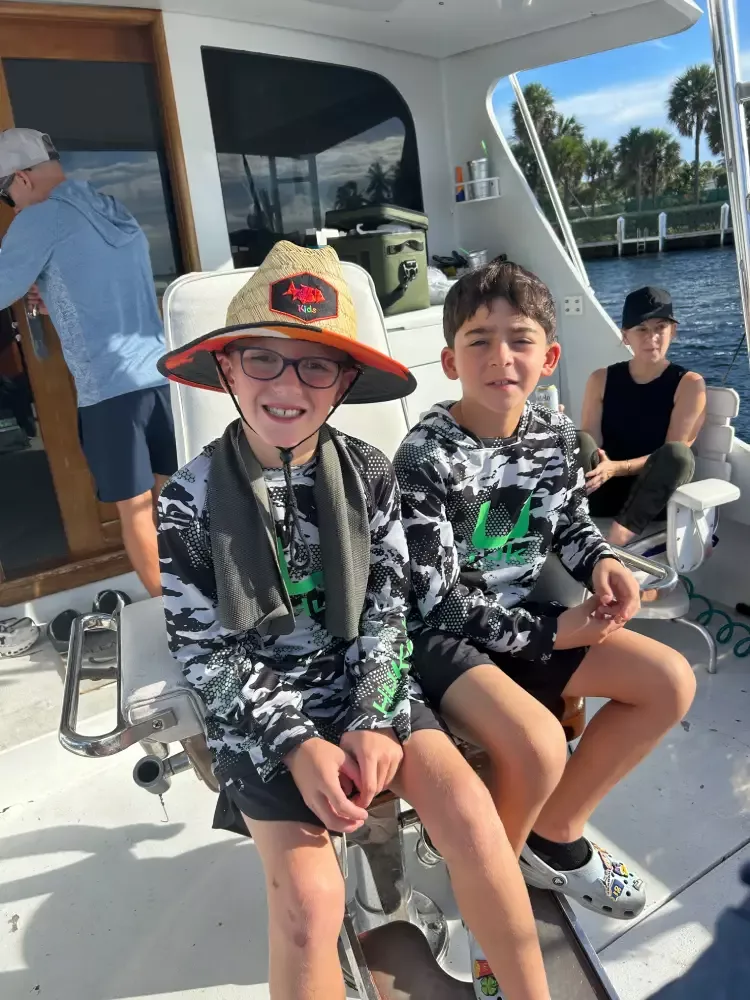 Kids enjoying an offshore fishing charter in South Florida with family and captain
